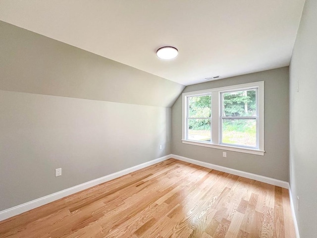 bonus room with light wood finished floors, visible vents, lofted ceiling, and baseboards