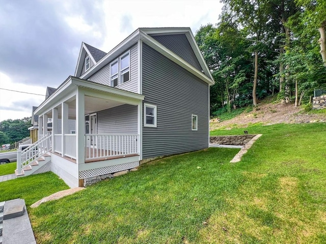 view of side of property featuring a porch and a lawn