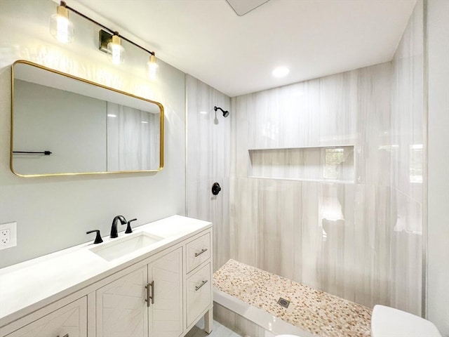 bathroom with vanity and a tile shower