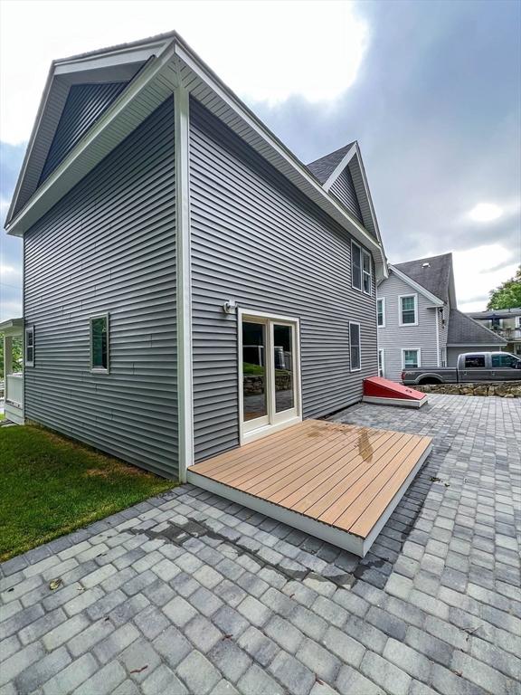 back of house with a wooden deck and a patio area