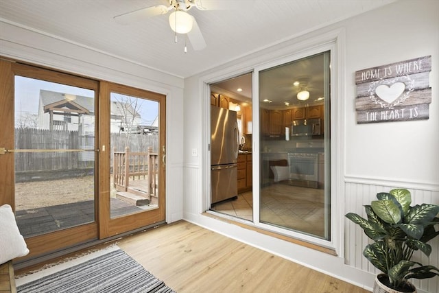 doorway to outside with ceiling fan, crown molding, and light hardwood / wood-style floors