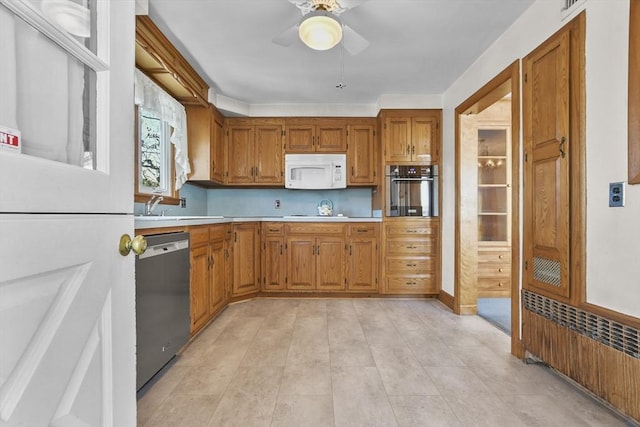 kitchen with ceiling fan, appliances with stainless steel finishes, sink, and radiator heating unit