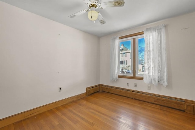 unfurnished room featuring wood-type flooring, a baseboard heating unit, and ceiling fan