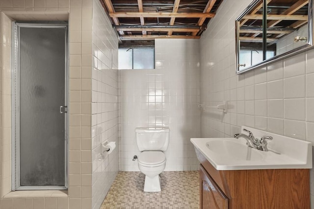 bathroom featuring tile patterned floors, toilet, a shower with shower door, tile walls, and vanity