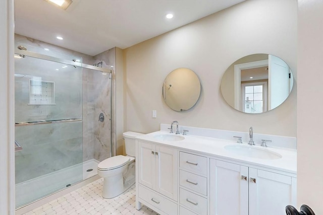 bathroom featuring vanity, toilet, and a shower with door