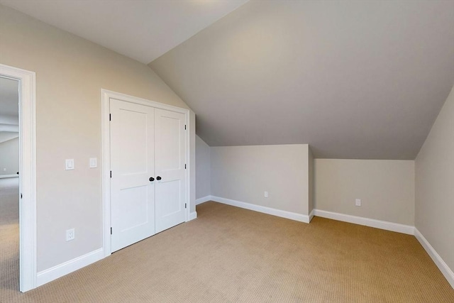 additional living space featuring light colored carpet and lofted ceiling