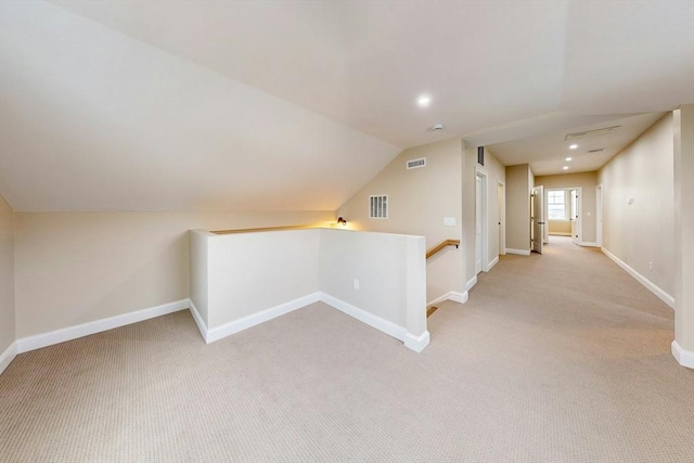 corridor featuring lofted ceiling and light carpet