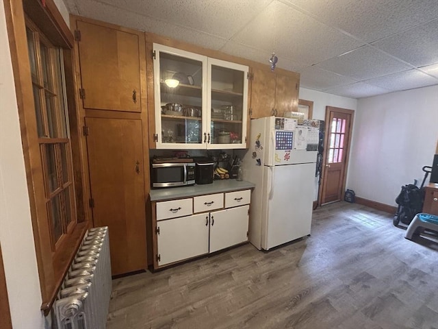 36 Edwards St, Quincy, MA 02169 - kitchen with freestanding refrigerator, radiator heating unit, stainless steel microwave, light wood-type flooring, and a drop ceiling