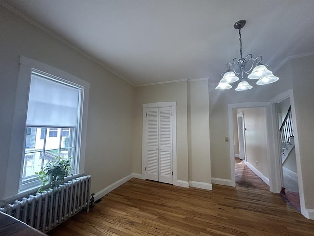 36 Edwards St, Quincy, MA 02169 - unfurnished dining area with radiator, ornamental molding, wood finished floors, a chandelier, and baseboards