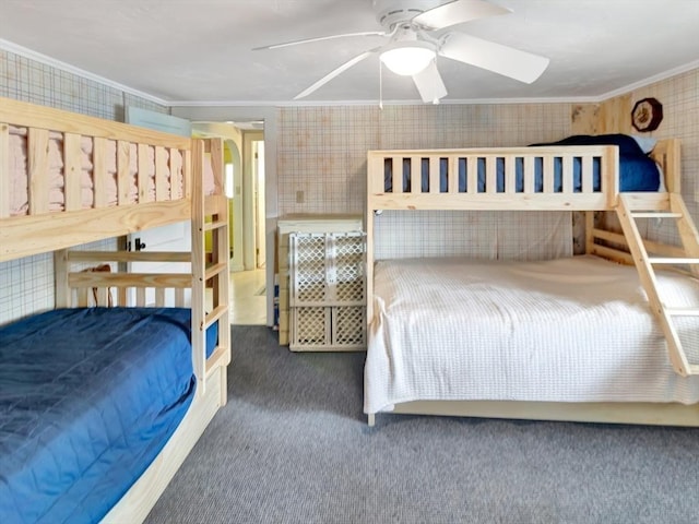 bedroom featuring ornamental molding, carpet, wallpapered walls, and a ceiling fan