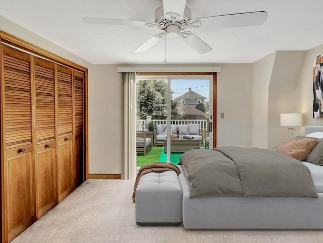 bedroom with access to outside, a closet, light colored carpet, a ceiling fan, and baseboards