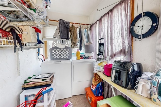 clothes washing area with a wealth of natural light, washing machine and clothes dryer, laundry area, and carpet flooring