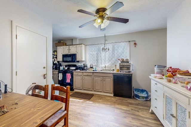 kitchen featuring black appliances, a ceiling fan, light wood finished floors, and a sink