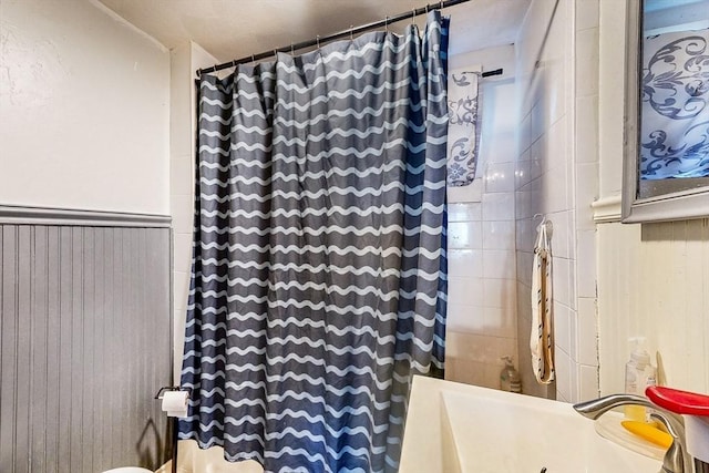 full bath featuring a shower with shower curtain and a sink