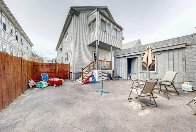 rear view of property with stairway, a patio, and a fenced backyard