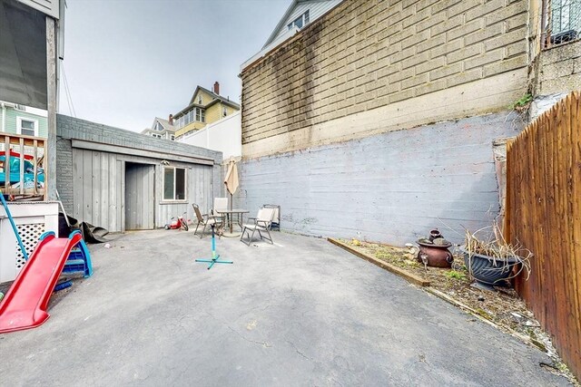 view of patio / terrace featuring a fenced backyard, a shed, outdoor dining area, and an outdoor structure