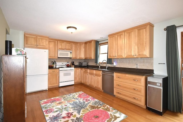 kitchen featuring white appliances, light wood finished floors, light brown cabinetry, and dark countertops