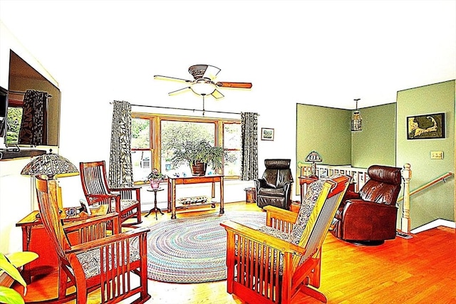 living area with a ceiling fan and wood finished floors