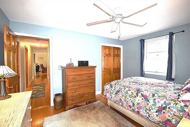 bedroom featuring wood finished floors, a ceiling fan, and a closet