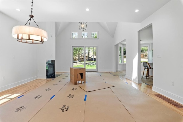 living room featuring high vaulted ceiling and a notable chandelier