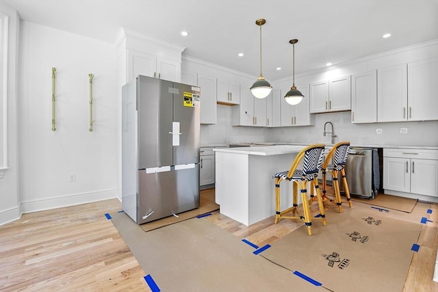 kitchen with white cabinetry, decorative light fixtures, light hardwood / wood-style flooring, and stainless steel appliances