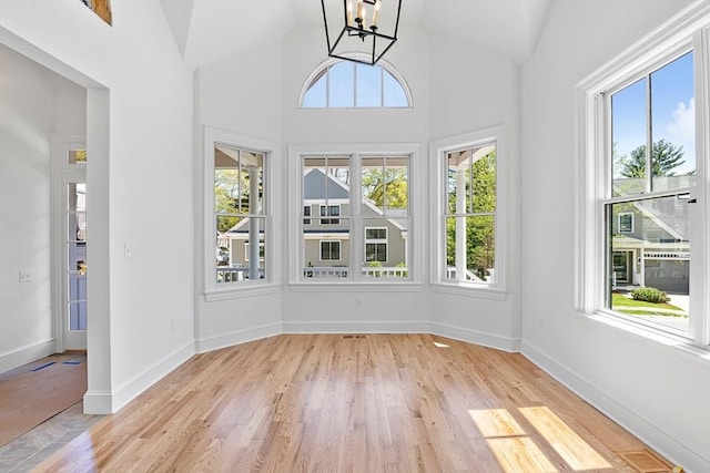 unfurnished sunroom featuring lofted ceiling and a chandelier