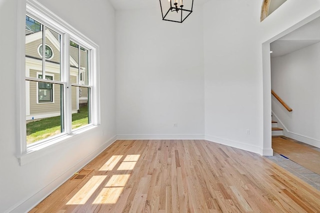 unfurnished dining area with light hardwood / wood-style flooring and a notable chandelier