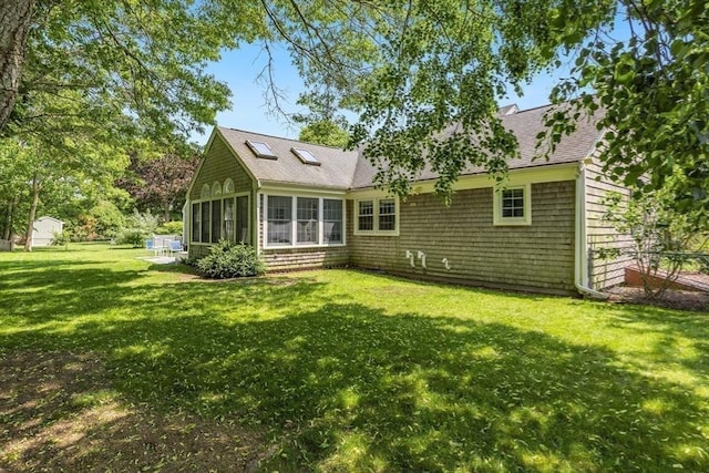24 Emerald Ln, Falmouth, MA 02536 - rear view of house featuring a sunroom, a lawn, and roof with shingles
