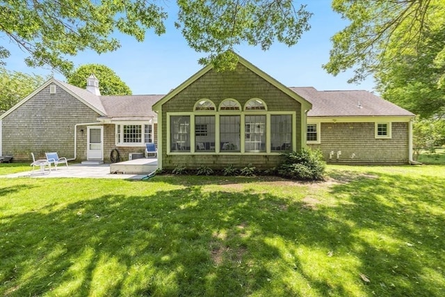24 Emerald Ln, Falmouth, MA 02536 - rear view of property featuring a patio, a chimney, a lawn, and a shingled roof