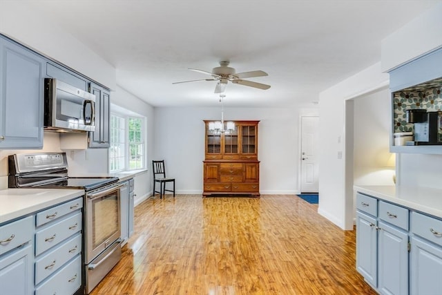 24 Emerald Ln, Falmouth, MA 02536 - kitchen with appliances with stainless steel finishes, light countertops, ceiling fan, light wood finished floors, and a chandelier