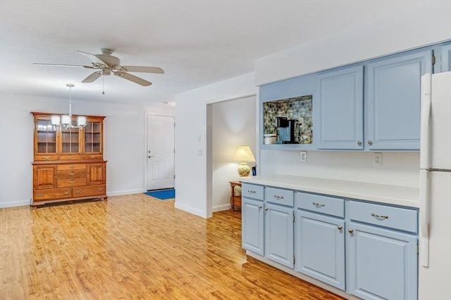 24 Emerald Ln, Falmouth, MA 02536 - kitchen with freestanding refrigerator, blue cabinetry, and a ceiling fan