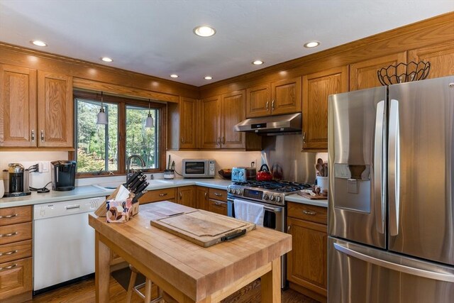 11 Polaris Dr, Mashpee, MA 02649 - kitchen featuring under cabinet range hood, appliances with stainless steel finishes, brown cabinets, light countertops, and a sink