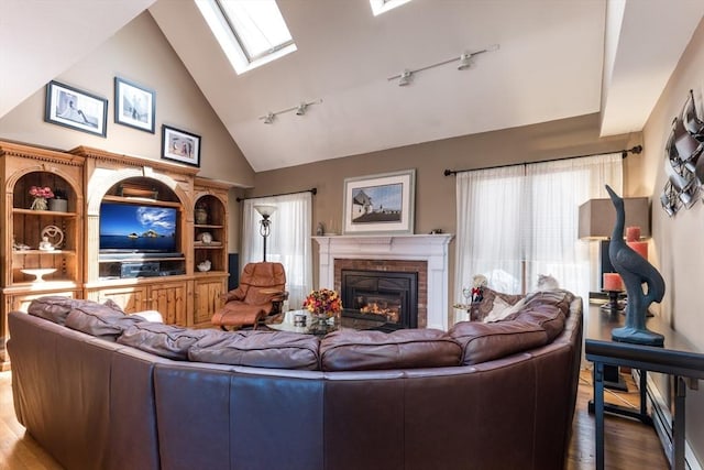 11 Polaris Dr, Mashpee, MA 02649 - living area featuring dark wood-style floors, track lighting, a healthy amount of sunlight, and a glass covered fireplace