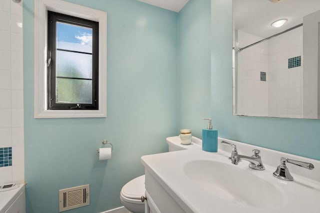 full bath featuring toilet, a shower, and vanity
