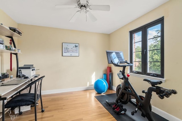 workout room featuring baseboards, light wood-style flooring, and a ceiling fan