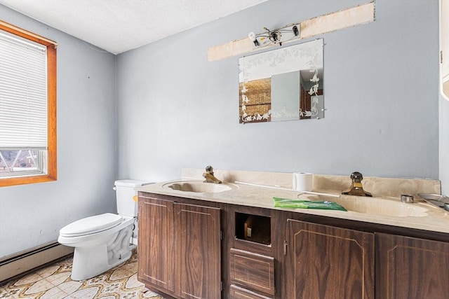 bathroom featuring toilet, tile patterned flooring, baseboard heating, and a sink