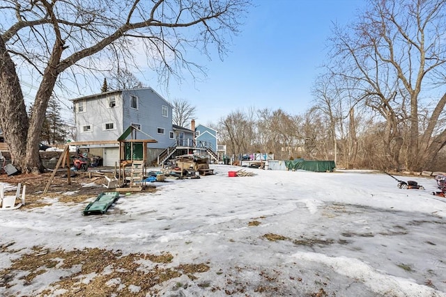 yard covered in snow featuring a deck and stairs