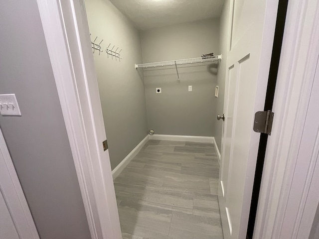 clothes washing area with laundry area, wood finished floors, electric dryer hookup, and baseboards