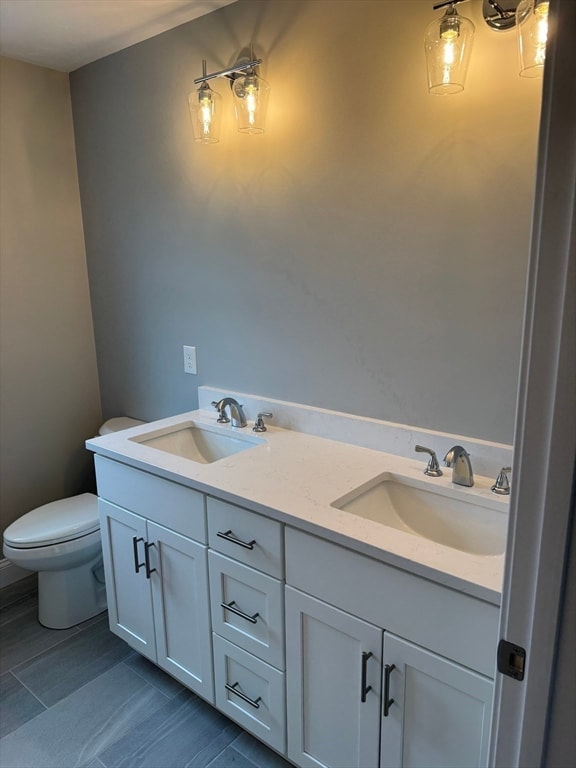 full bathroom featuring a sink, toilet, and double vanity