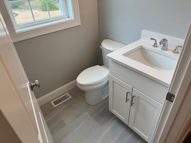 bathroom featuring toilet, baseboards, visible vents, and vanity