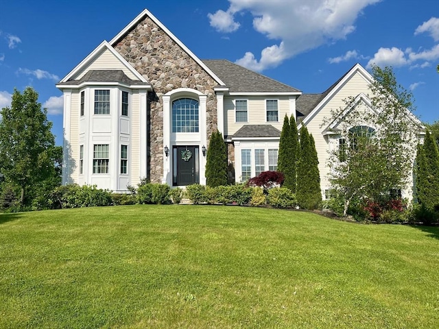 view of front of house with stone siding and a front lawn