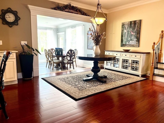 dining area featuring ornamental molding and dark wood finished floors