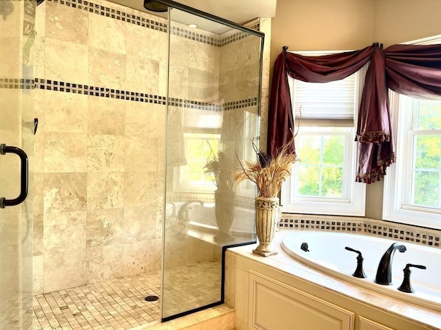 bathroom with a stall shower and a bath