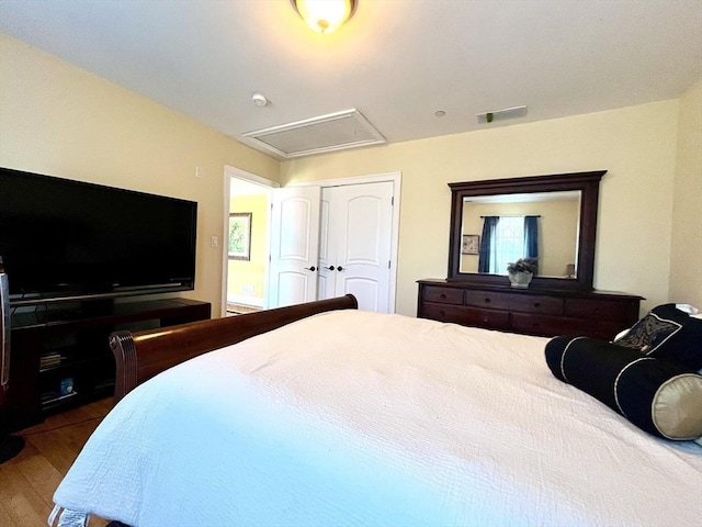 bedroom featuring a closet, visible vents, and wood finished floors