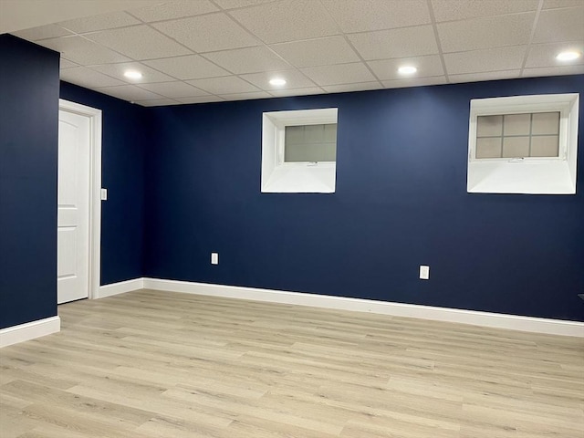 finished basement featuring recessed lighting, a drop ceiling, light wood-style flooring, and baseboards