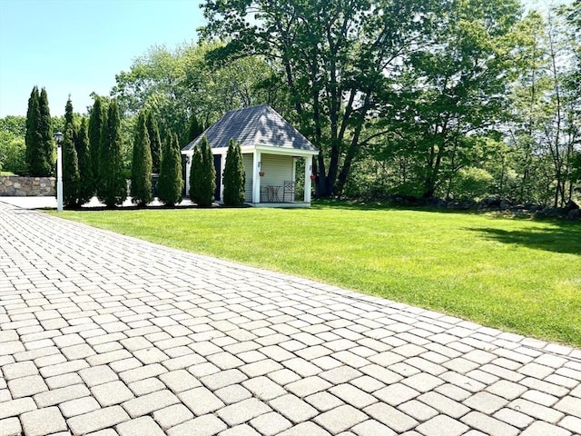 view of community with a lawn and an outdoor structure