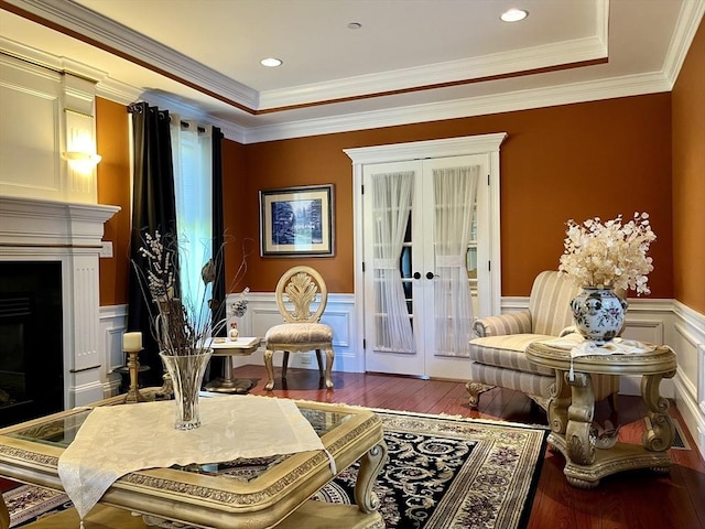 living area featuring wainscoting, a fireplace, wood finished floors, and french doors