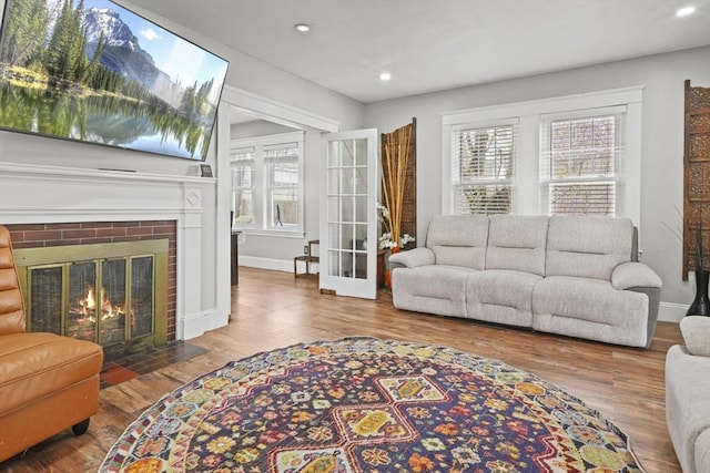 21 Vernon St, Lowell, MA 01850 - living room with recessed lighting, a brick fireplace, wood finished floors, and a wealth of natural light