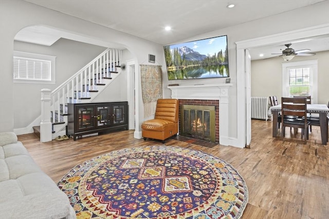 21 Vernon St, Lowell, MA 01850 - living area featuring stairway, arched walkways, radiator heating unit, and wood finished floors