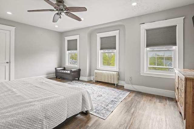 21 Vernon St, Lowell, MA 01850 - bedroom with baseboards, multiple windows, radiator heating unit, and wood finished floors
